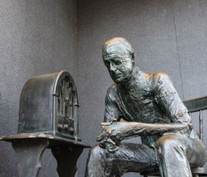 statute of a sitting man listening to the radio
